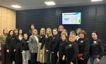 Групове фото жінок на фоні звукоізолюючої стіни та телевізору.