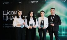 Три жінки та чоловік позують з нагородами.