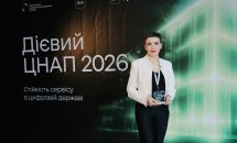 Жінка з короткою зачіскою позує з нагородою.