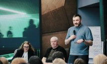 Чоловік з бородою розповідає щось у мікрофон.