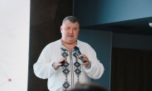 Чоловік у вишитій сорочці тримає мікрофон