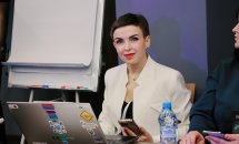 Жінка з короткою зачіскою посміхається.