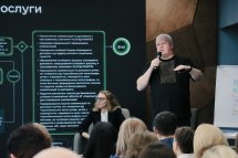 Чоловік у чорному одязі розповідає щось у мікрофон.