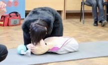 Жінка перевіряє дихання на манекені