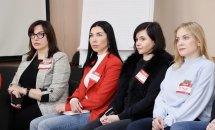 Чотири жінки сидять у приміщенні.