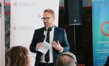 Чоловік в окулярах тримає мікрофон у руках.