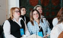 Група жінок сидять у залі.