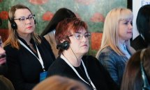 Декілька жінок сидять у залі.