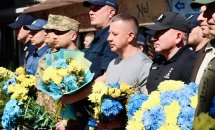 Група чоловіків з букетами квітів.