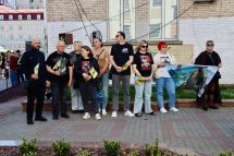Група людей стоять з прапорами.