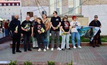 Група людей стоять з прапорами.