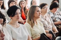 Група жінок сидять у приміщенні.