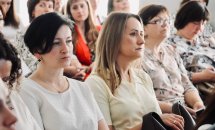 Група жінок сидять у приміщенні.