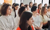 Група людей сидить у приміщенні.