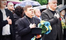 Троє чоловіків тримають руку на серці.