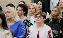 Багато жінок сидять у залі.