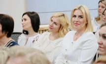Жінки у білому одязі сидять у залі.