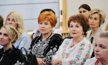 Жінки у вишиванках сидять у приміщенні.