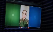 Жінка у військовій формі на екрані.