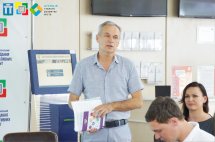 Чоловік у світлій сорочці щось розповідає.