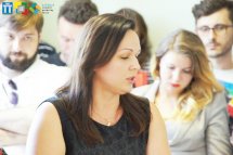 Жінка в чорній сукні бере участь у заході.