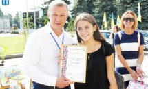 Чоловік з дівчиною позують для фото з грамотою.
