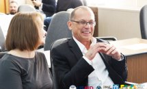 Чоловік та жінка сидять у приміщенні та посміхаються.