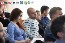 Чоловіки та жінки сидять у приміщенні.