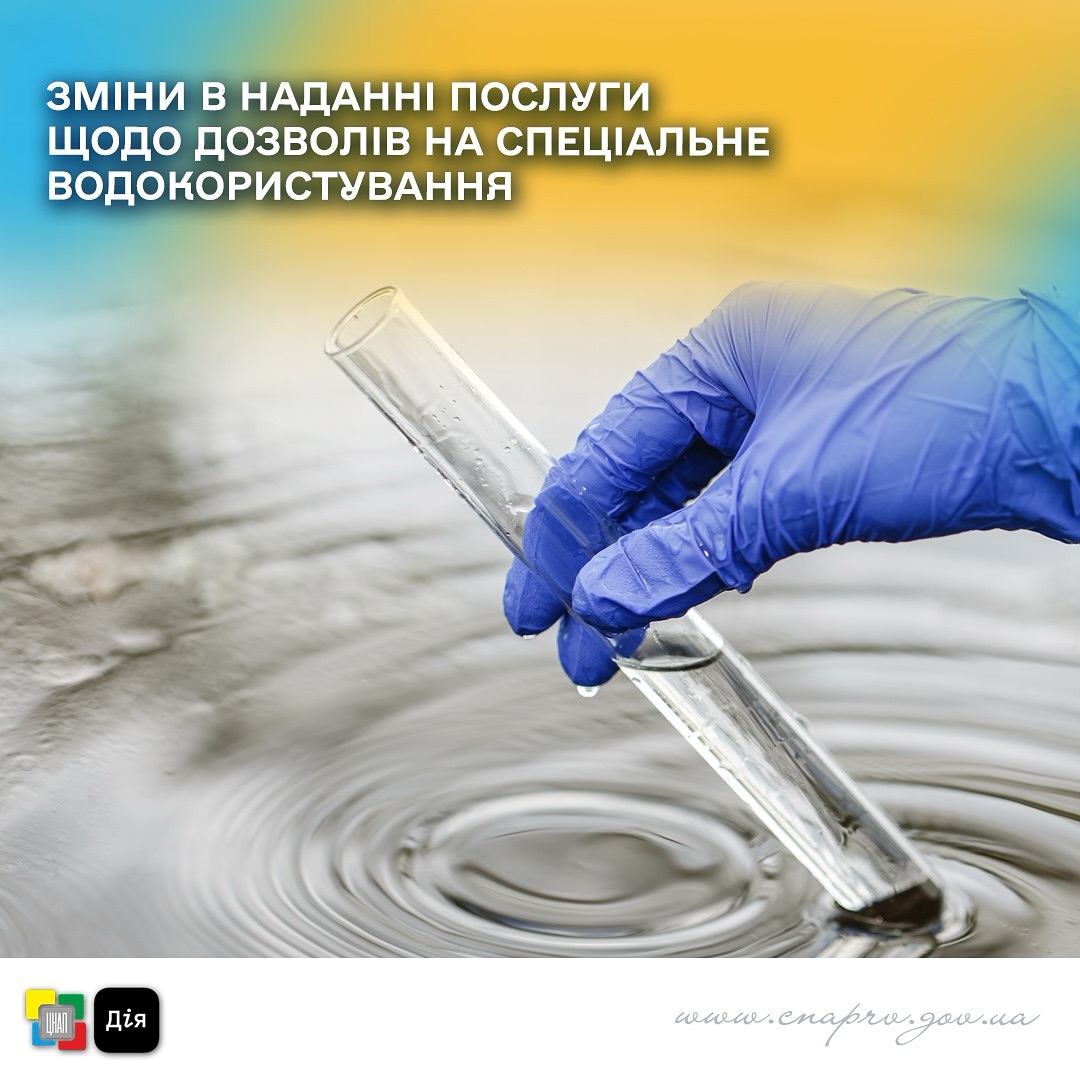 Рука в синій рукавиці тримає пробірку з прозорою рідиною, ймовірно водою.