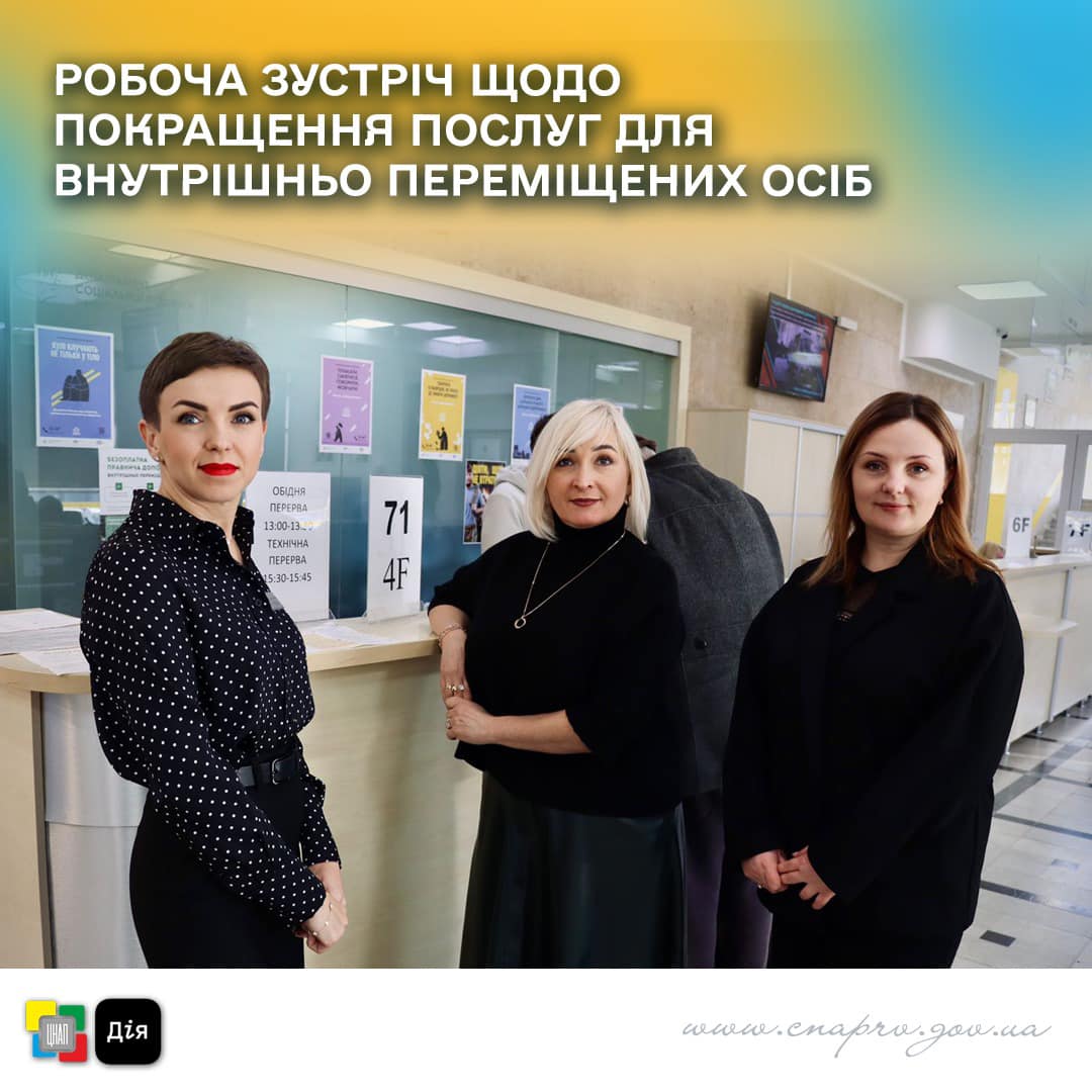 Три жінки стоять біля стійки та дивляться у камеру.