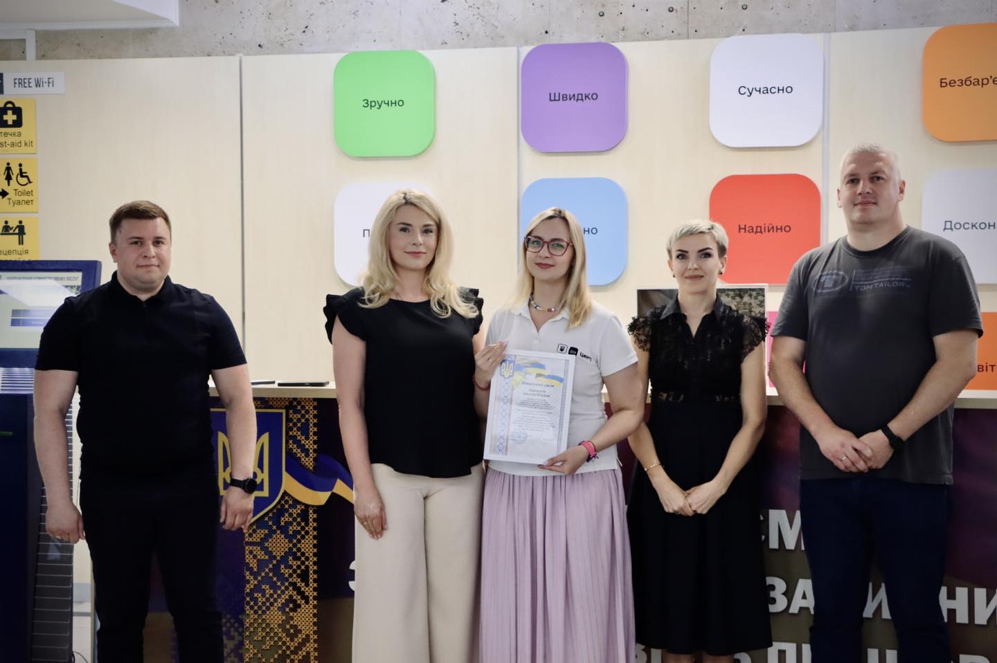 П'ятеро людей стоять разом. Жінка в центрі тримає почесну грамоту з написом 'Фещук Лілії Василівни'.
