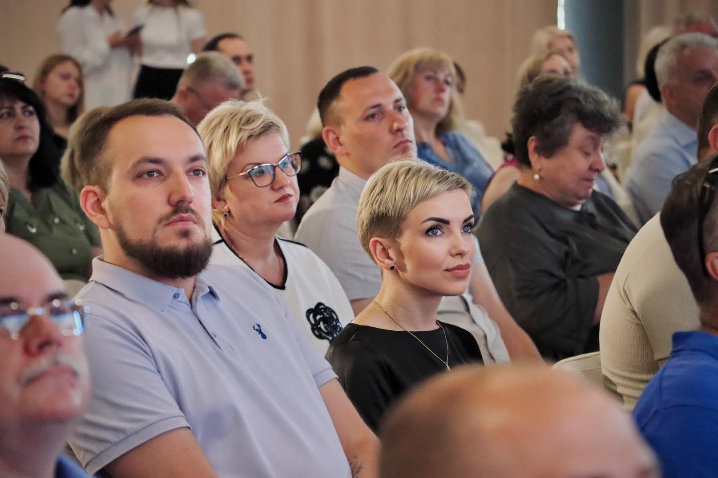 Група людей, серед яких заступник міського голови Євгеній Іванішин та заступник директора Департаменту цифрової трансформації та забезпечення надання адміністративних послуг РМР Наталія Шустик сидять у залі та уважно слухають презентацію