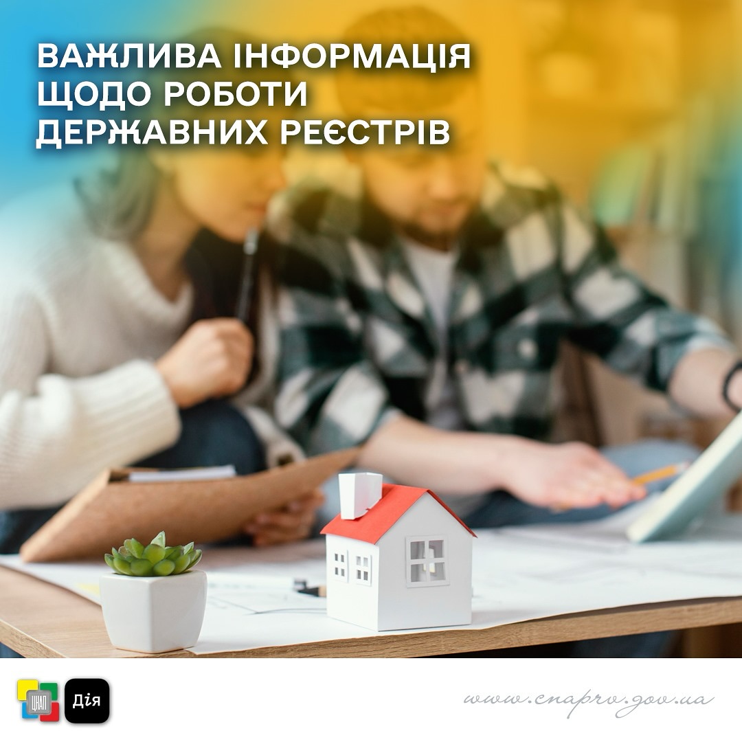 Паперовий будинок з червоним дахом стоїть на столі. На задньому плані чоловік і жінка. 