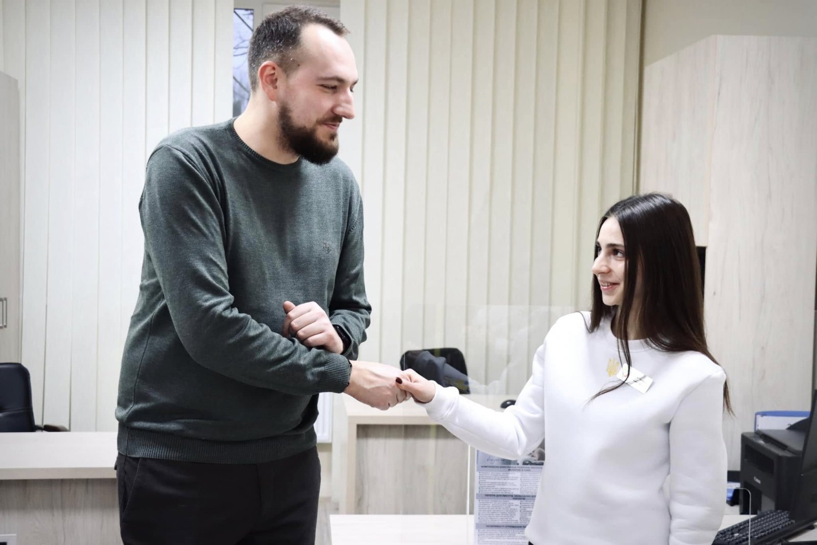 Чоловік та дівчина стоять у приміщені віддаленого робочого місця ЦНАПу в місті Рівному.