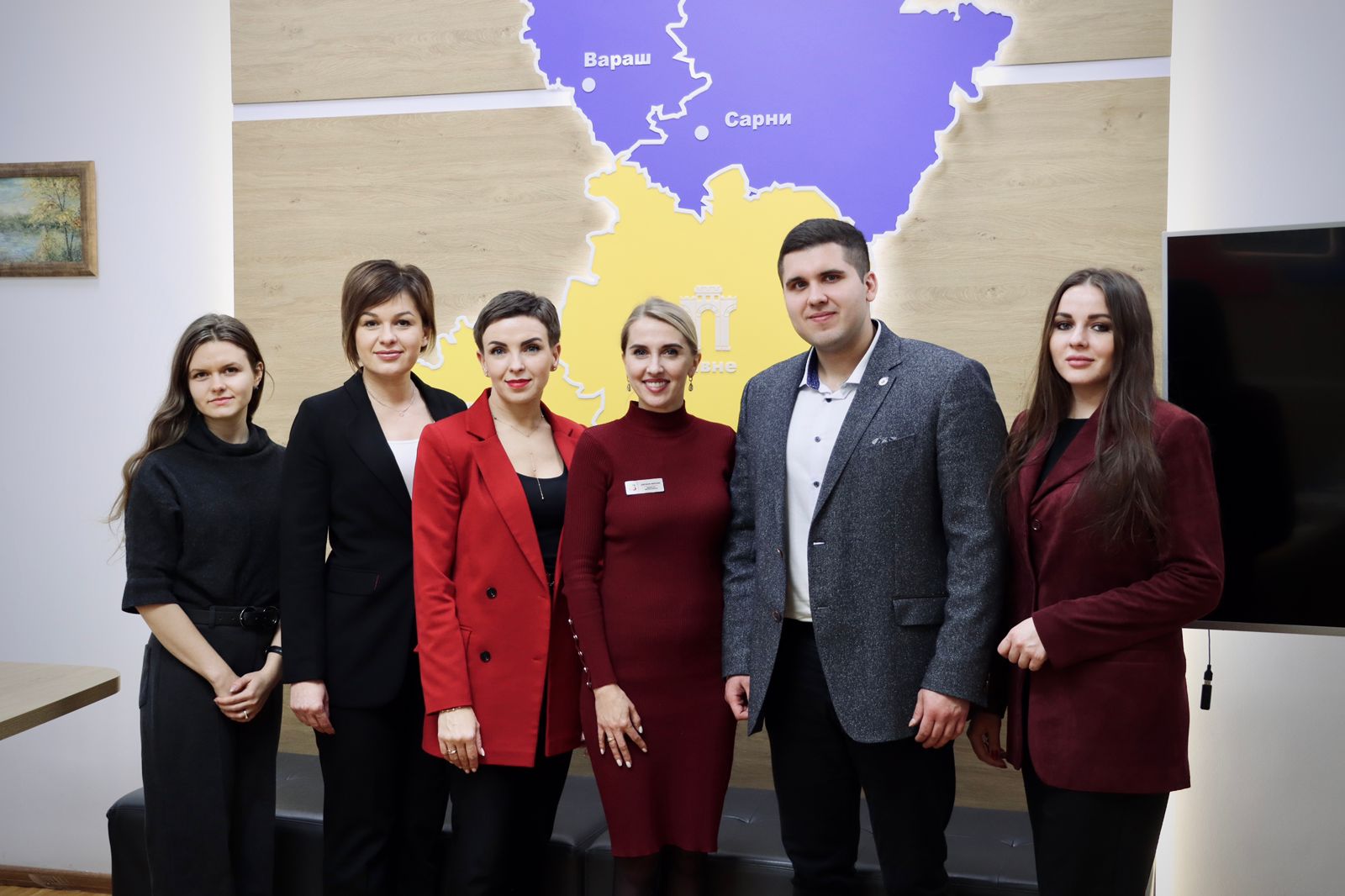 Група людей позує для фото у приміщенні.