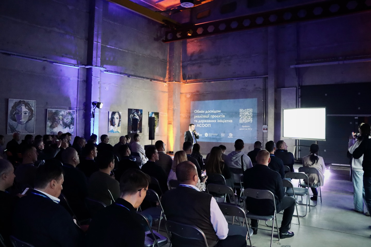 Багато людей сидять у приміщенні.