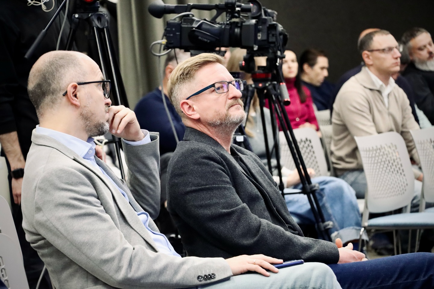 Люди сидять у залі.