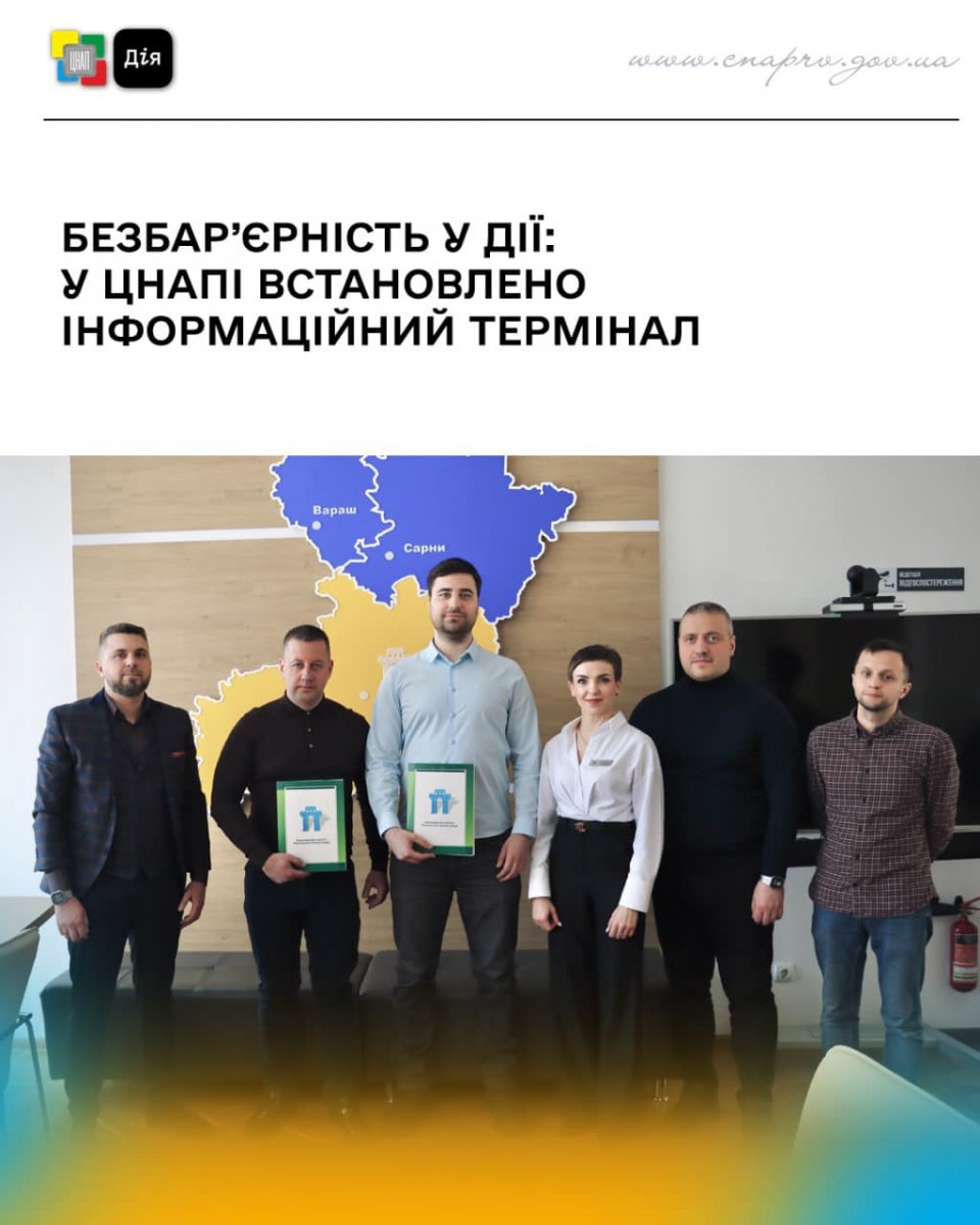 Група з п’яти чоловіків і жінки у білій блузці стоять перед картою Рівненської області в приміщенні.