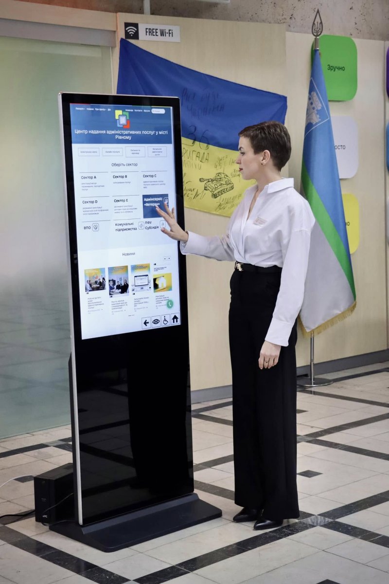 Жінка взаємодіє з терміналом у ЦНАПі. На терміналі зображена офіційна сторінка ЦНАП у місті Рівне
