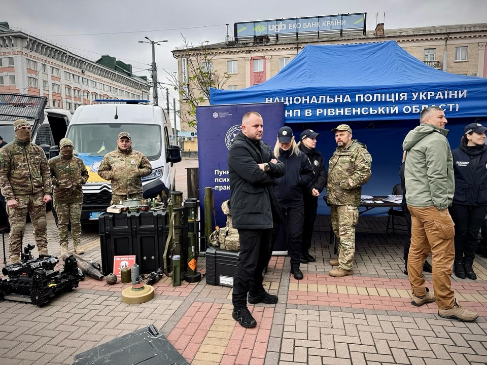 Військові та поліцейські біля намету з технікою та озброєнням