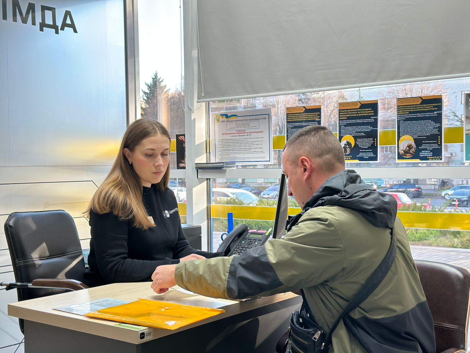 Жінка сидить за робочим столом, напроти неї сидить чоловік.