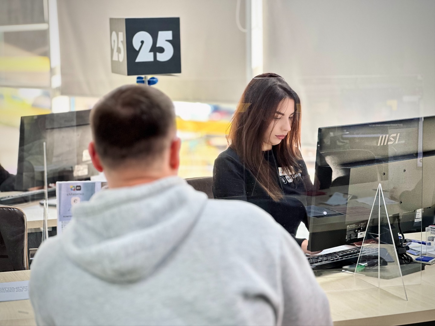 Жінка працює за комп'ютером, напроти сидить чоловік.