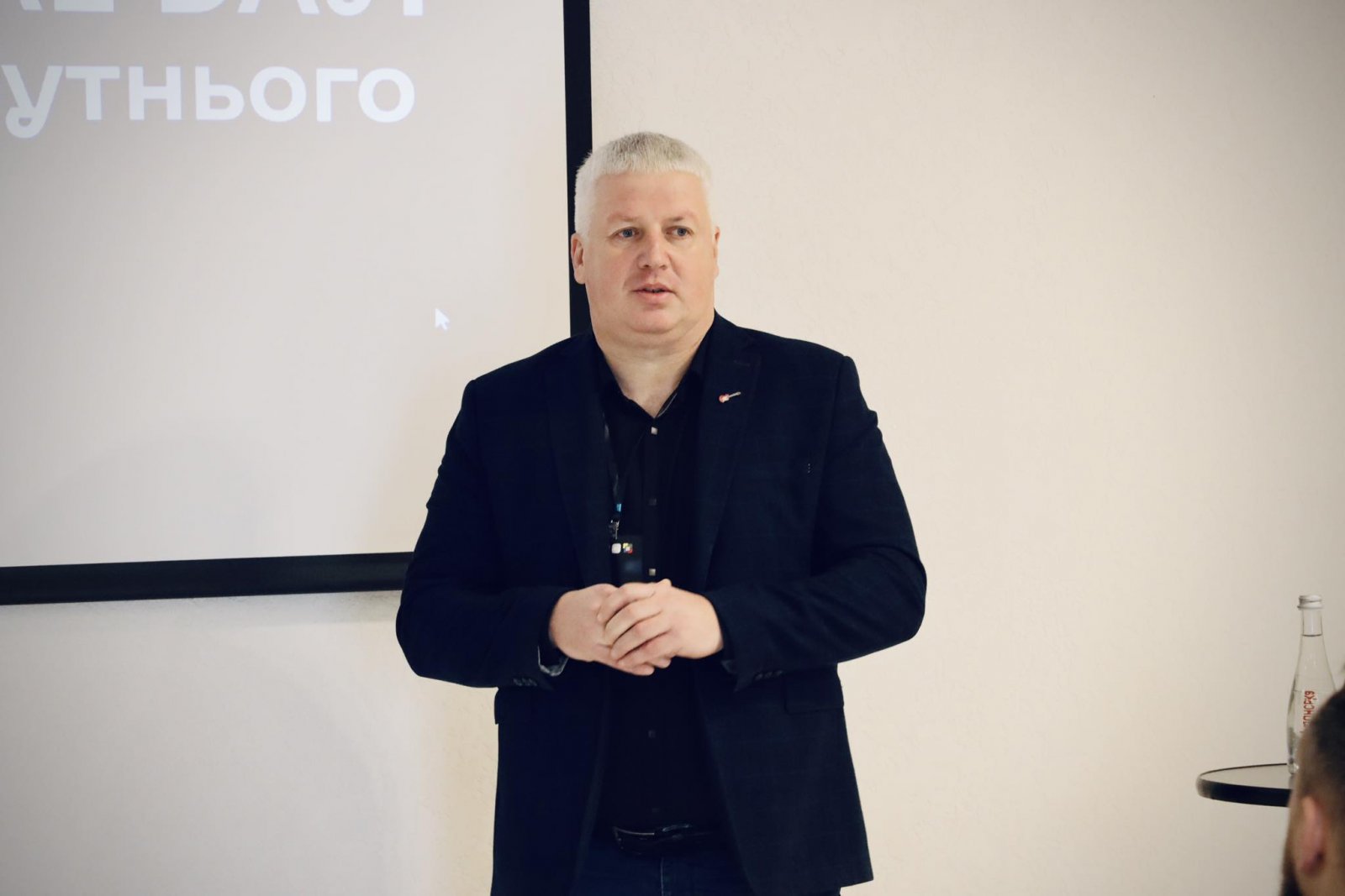 Чоловік у чорному одязі щось розповідає.