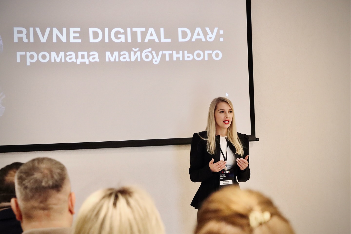 Жінка зі світлим волосям щось розповідає