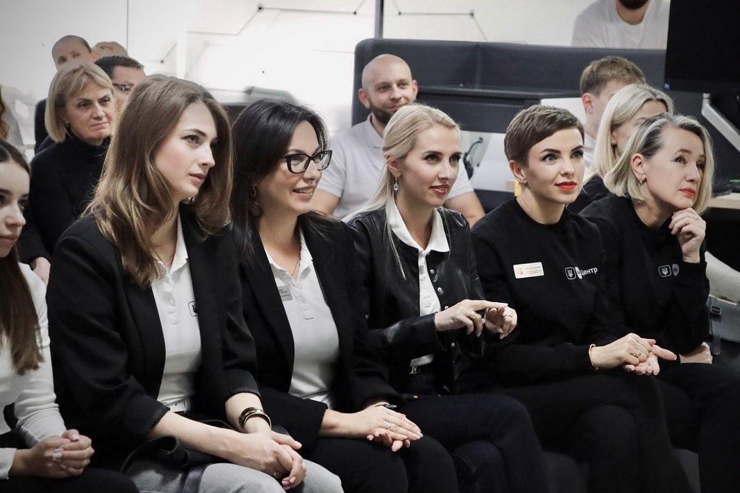 Люди сидять у залі та уважно слухають