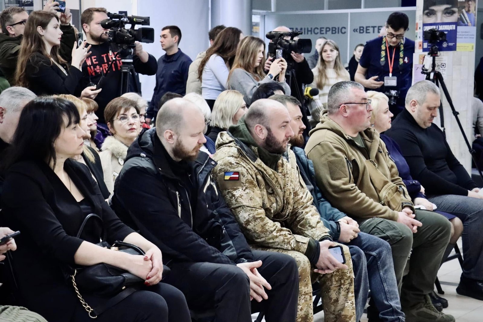 Люди сидять в приміщенні ЦНАПу і слухають доповідь.