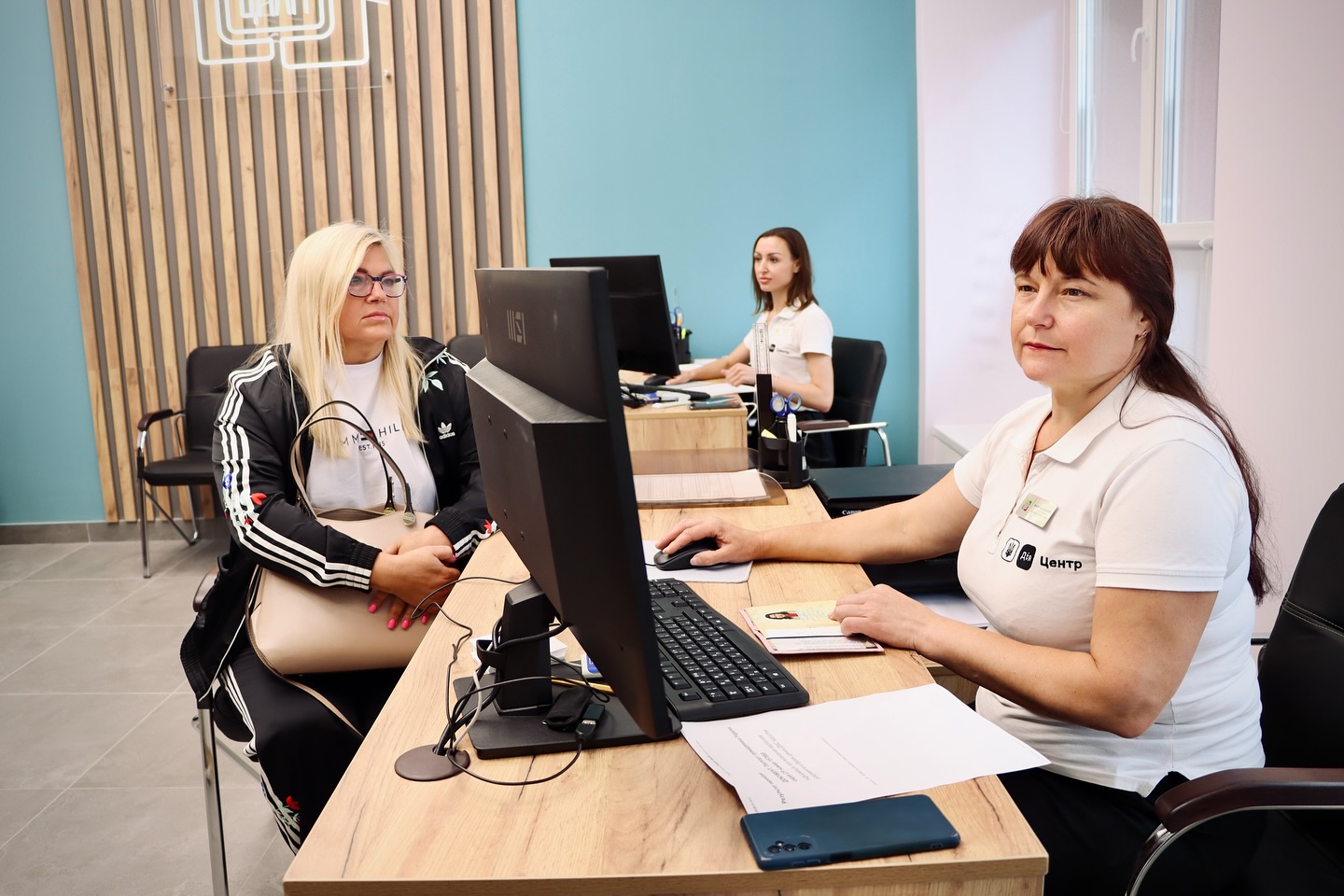 Дві працівниці та відвідувачка перебувають у приміщенні.