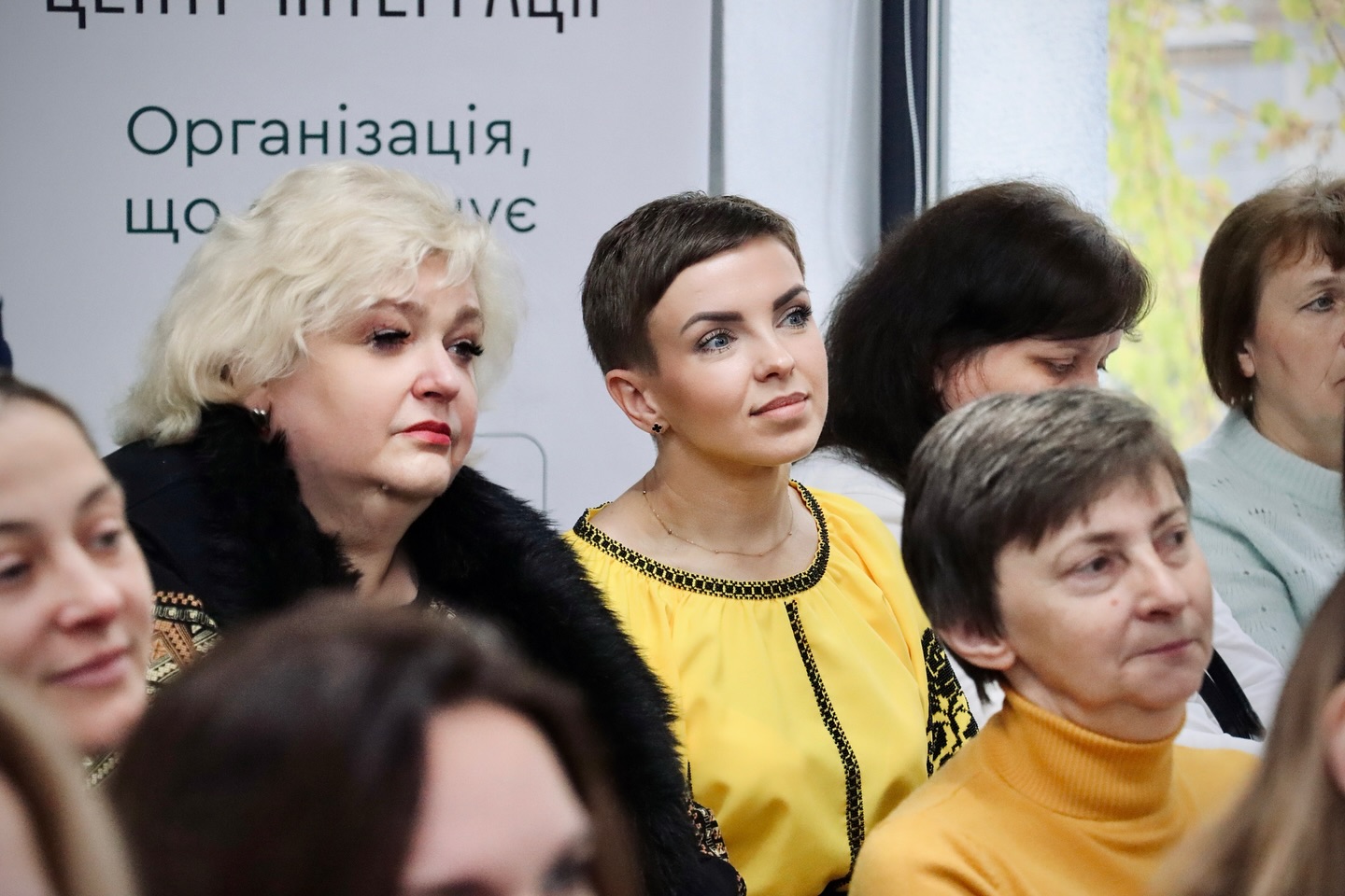 Група жінок сидять у приміщенні.