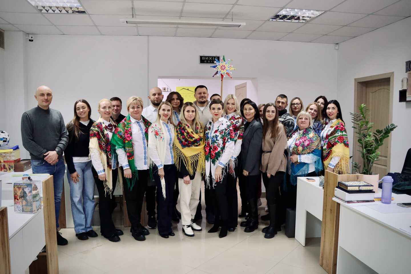 Група людей у вишитих сорочках позує для фото.