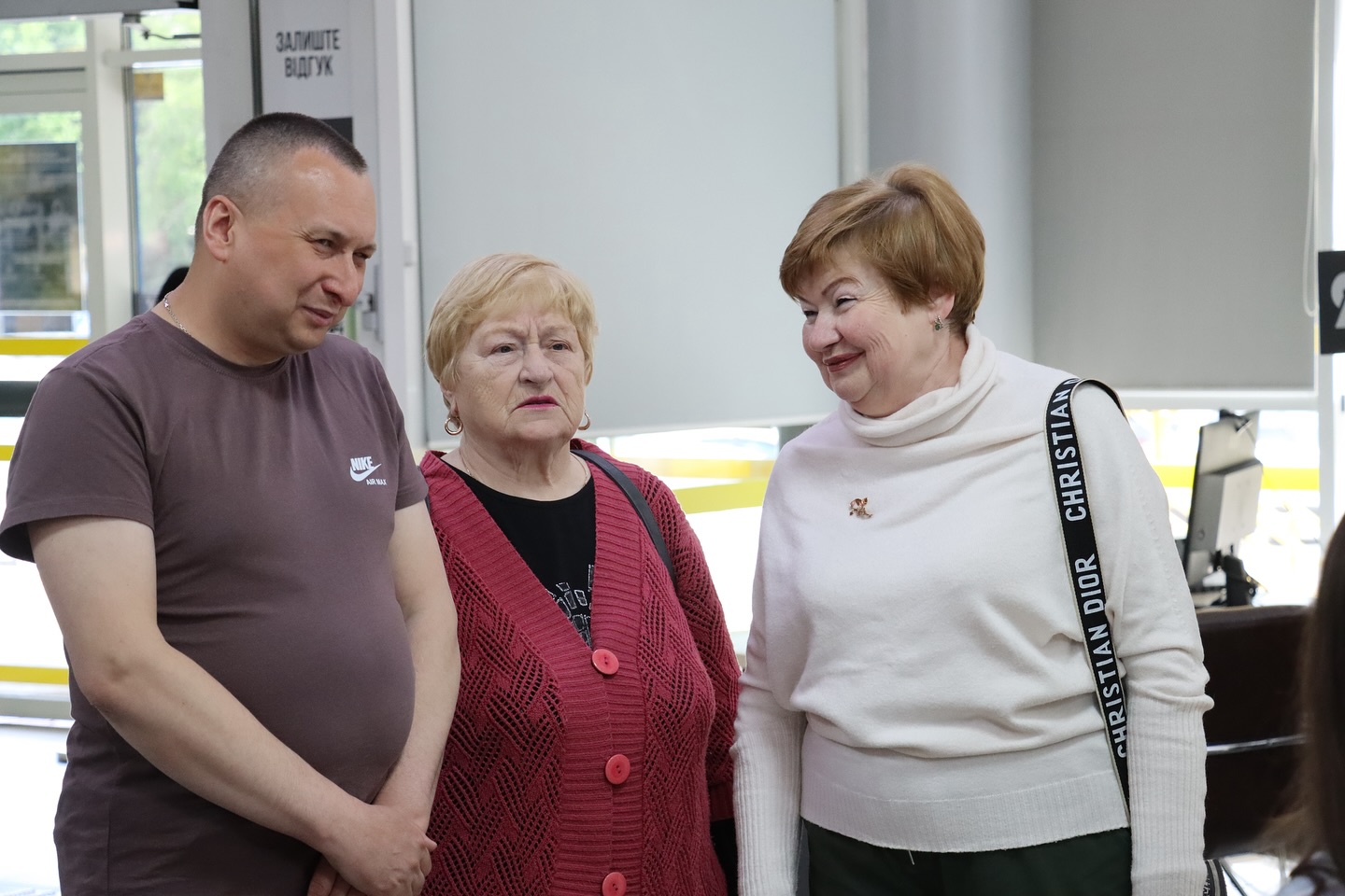 Дві жінки та чоловік перебувають у приміщенні.